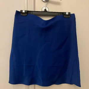 Silkeskjol - Blå silkes kjol som aldrig kommit till användning då det inte riktigt är min stil. helt oanvänd med prislapp på. inga defekter eller fläckar! hör av er om ni har några frågor eller vill ha fler bilder!🤍