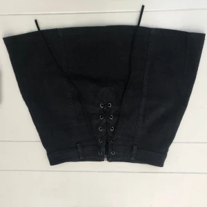 Kjol - Säljer min svarta lite emo aktiga kjol då den inte är min storlek. Den är i väldigt bra skick och lite andvänd. Midjemått är 73 men kan knytas åt och låssas med hjälp av snöre på framsidan. skriv för intresse av fler bilder. 