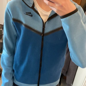 Nike Tech - Nike Tech i snygg blå färg, lite defekt nere på tröjan som visas i bilden, priset kan diskuteras! 8/10 skick