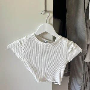 Vit topp med knyte i ryggen  - Toppen är i väldigt gott skick och knappt använd. 