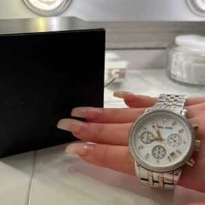 Silver Klocka  - Bra skick funkar som den ska, använt den inte så värst mycket och finns inte att köpa i butik längre. Silvrig med lite guld detaljer. Kostar i vanliga fall 3000 men kommer sälja den för 1500. Kan gå att få det billigare!