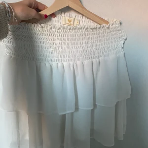 Vit Chelsea volangkjol - Säljer en vit Chelsea kjol i storlek M. Den är i bra skick. Används ej då den är för stor på mig. Köpt för 449kr.