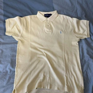 Ralph Lauren Tröja - Säljer min gula Ralph Lauren piketröja som är använd fåtal gånger. Den är storlek S och är perfekt för sommaren samt folk som vill ha ett otroligt snyggt plagg.