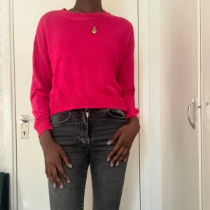 Röd-rosa stickad tröja - Tröjan är i bra skick, jag har bara använt den ett få tal gånger. Den är dock ganska kort nästan; den faller lite under naveln (jag är 173 CM)