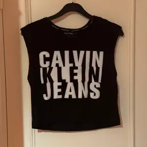 En svart kort crop top från Calvin Klein Jeans märke. Köpt på zalando längesen, i fint begagnat skick. Storlek XS.  Katter finns i hemmet