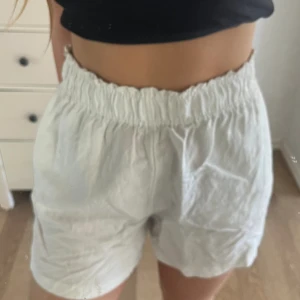 Linneshorts vita - Jag säljer ett par vita högmidjade  linneshorts från H&M. Shortsen är endast använda ett fåtal gånger och är i bra sick(tyvärr lite skrynkliga på bilden)Perfekt till sommaren🤩