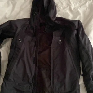 Haglöfs jacka - Bra skick men ett litet hål som inte syns, de 3dje bilden! Jackan är svart grå