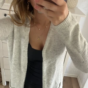 Grå stickad kofta  - Hejsan, jag säljer en ljusgrå kofta i en längre modell med fickor. Koftan är i ett jättefint sick och i princip oanvänd. Storleksmässigt= S/M