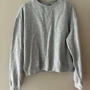 Ljusgrå sweatshirt från Weekday i storlek XS. 