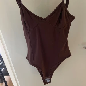 Bodysuit - Brun bodysuit från Boohoo. Lapp kvar. Endast testad 2 gånger  Kan upplevas liten i storlek 