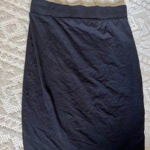 Svart rak kjol - Jätte söt tajt svart kjol. Går till knäna men man kan vika sen vid midjan om man vill ha den kortare. Köpt från lager 157 för några år sedan men som ny. 