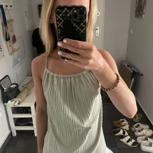 Grönt linne med öppen rygg från Ginatricot - Säljer mitt gröna linne i storlek xs från Gina då det inte kommer till någon användning längre💚 är i väldigt fint skick o är knappt använt!!