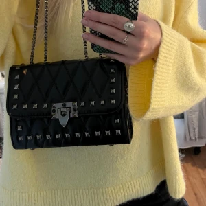 Axelväska med nitar - fin axelväska med nitar, går att ha som långt band som går över kroppen eller korta ner dom och ha över axeln. Rymlig och bra väska som får plats med mobil och mycket mer Använd ca 3 gånger så i nyskick 