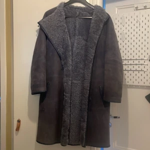 Mockakappa i strl S/XS(gråblå) - Mkt fin 3/4 mockakappa i gråblå ton. Säljes pga att den är för liten för mig. Skick bra, hängare gått av o liten reva, se bif bild. Fullt fodrad med tät och härlig päls och ärm som kan vikas upp efter behov. Asymetrisk krage. Har ni frågor, maila