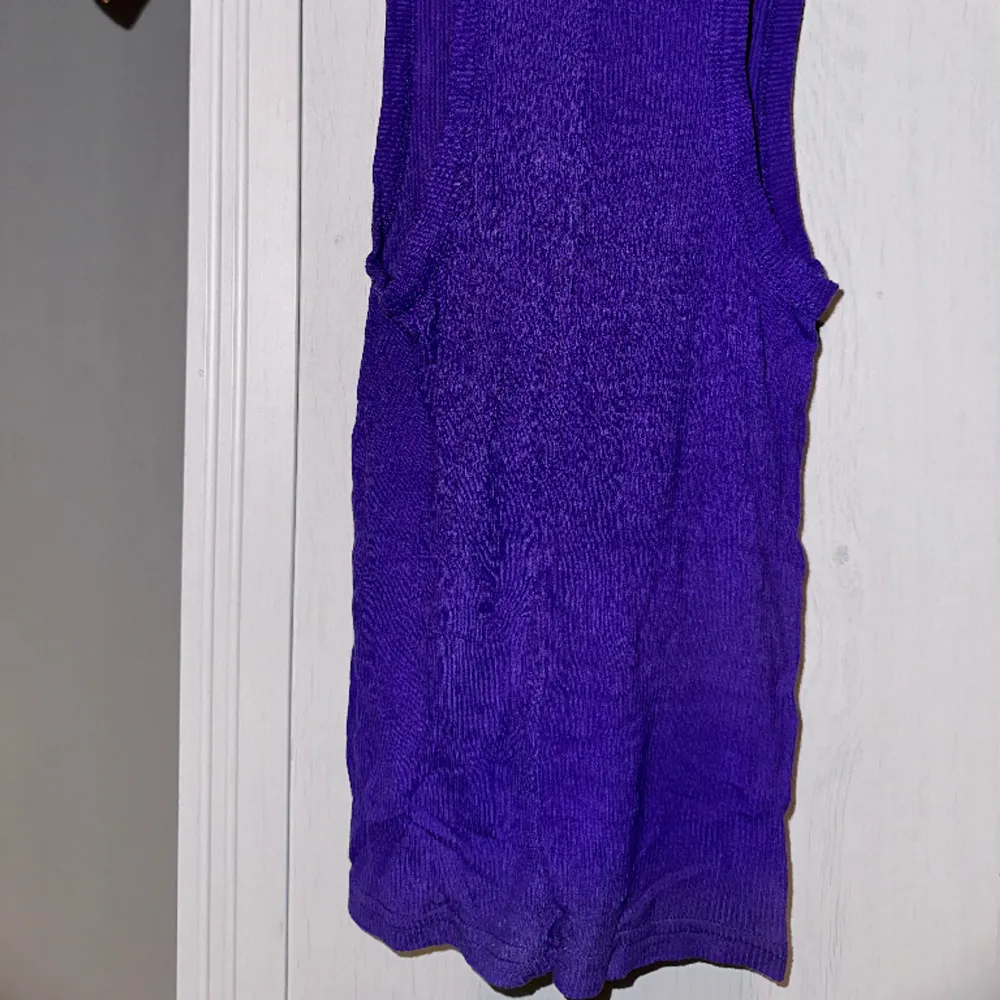 Bodycon semi-sheer vibrant purple tank top with contrast orange embroidered logo. Replicking. Too small on me. Gently used condition. Some fuzz but no pilling. No holes, tears, rips, stains, fading. Smoke and pet free storage space. . Toppar.