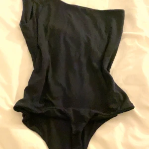 Tröja - En svart one shoulder body 