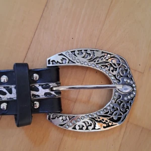 Bälte - Ett blingigt bälte i användt skick som enbart är synligt på baksidan många fina detaljer 120 cm långt. Köpt secondhand så vet inte vart det kommer från originellt. Säg till om du vill ha fler bilder