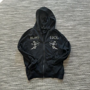 Rhine stone zip hoodie - En rhine stone zip hoodie från bling lucid. Skick 7-8/10. Skriv ifall ni har frågor eller vill ha fler bilder