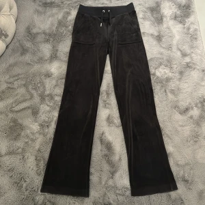 Juicy Couture - Ett par svarta juicy couture byxor från deras hemsida, bra material, stl XXS(kan passa XS), silvriga knappar och saknas en metalbit på ett snöre där fram. 
