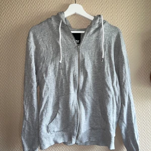 Grå Zip tröja - Grå zip tröja från lager 157. Ena snöret är lite sönder som man ser på bild.