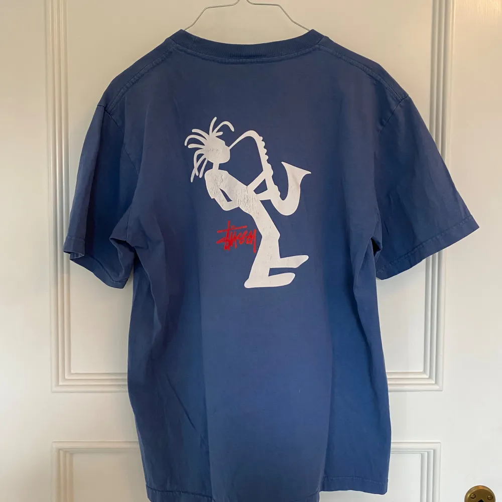 stussy t-shirt med Saxophone man motiv från 90/00-talet. Schysst kvalité och bra skick! 65cm längd, 46cm bredd axel till axel. . T-shirts.