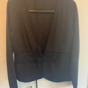 Kort kavaj  - Snygg kavaj med tygstycke runt midjan. Dolt spänne dolt i midjan .  Storlek L från vila