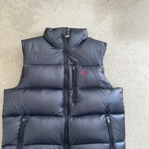 Ralph lauren dunväst  - En raffe väst med lite glansigt material som är perfekt till sommarkvällar och vår i mycket gott skick i storlek L, priset kan diskuteras vid snabb affär 