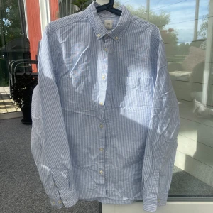 Vit och blå randig skjorta - Säljer en vit och blå randig skjorta från h&m🤩Kolla bilderna för detaljer!! Strl. M, modellen är ”regular fit”. I mycket bra skick🙌🏻Du får även med dig 2 extra knappar!! Så snygg på sommaren☀️Billiga kläder➡️min profil🤗