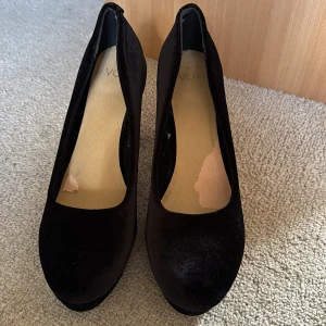 Svarta klackskor  - Storlek 41. Har använts en gång på bröllop. Hade silikon ilägg därav skadorna i sulan, är bara översta lagret som gått av och inget på sulan i sig som är sönder. I övrigt inget slitage.  Är väldigt sköna men kommer inte till användning för mig. 