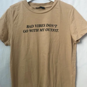 Text T-shirt  - Ljusbrun text T-shirt i gott skick  • Storlek M