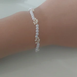 Armband  - Ett blommigt armband med pärlor 💐🪩 Nästan aldrig använt och perfekt till sommaren 🏖💐