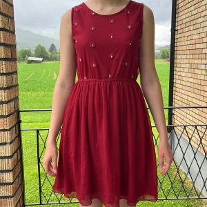 Vinröd klänning  - Vinröd klänning med broderade blommor.