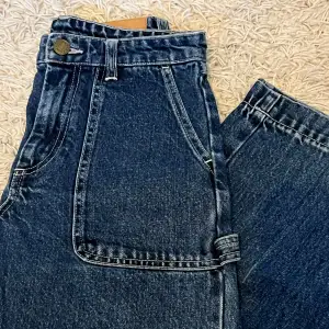 Blåa jeans från Monki i okej skick! Storlek 24 i midjemått! Små slitningar men inget märkvärdigt. Modell - lite kortare vida jeans, en detalj på vänster byxben! Pris 139 + frakt