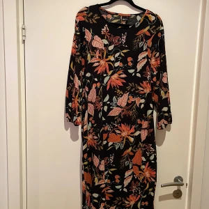 Blommig klänning i stretchigt och skönt material  - Lång klänning med en liten slits i ena sidan.normal i storlek och inte använd mer än ett oar gånger. 