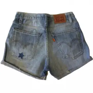 Snygga jeansshorts från Levi’s med tyglappar och en stjärna på! Högmidjade/midrise, Midjemått 66cm