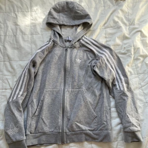 Grå adidas zipup hoodie - Grå adidas hoodie (zipup) riktigt mysig!!! 
