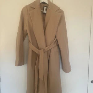 Beige kappa - Helt oanvänd beige kappa strl 36.