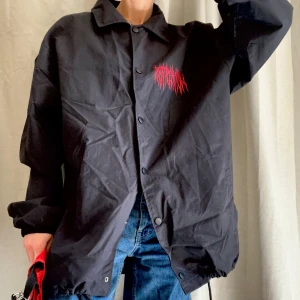 Tunn jacka 90-tal - 90-tal när det är som bäst! Den är jämnt svart och riktigt svart men det går inte att få bra på bilderna. Har snöre nertill, stängs med tryckknappar. Kan ej se vad det står på trycket men ball iaf :) Har använt oversized 