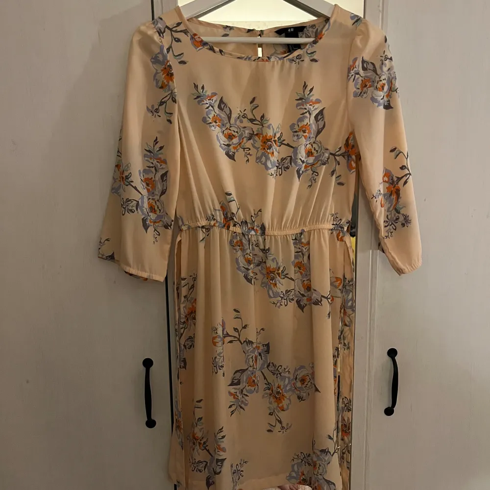 En aprikos blommig klänning med snörning i midjan från H&M i strl 34!💓. Klänningar.