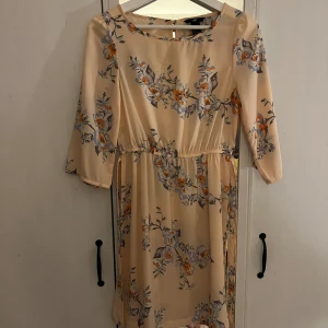 Blommig klänning - En aprikos blommig klänning med snörning i midjan från H&M i strl 34!💓