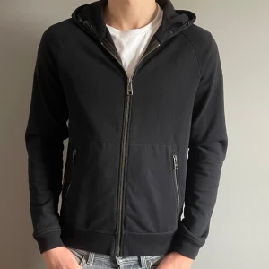 PRADA zip hoodie  - Säljer denna riktigt snygga Prada zip hoodie då den är lite för liten. Den är sparsamt använd och i mycket bra skick 9/10.  Skiv vid minsta intresse. (Äkta).