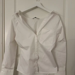Vit skjorta  - En vit skjorta som är halvt offshoulder från Zara. 