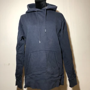 Blå hoodie - Finns en fläck på magen. Herr modell men funkar även som dam. Ärmlängd ca 66cm. Längd ca 74cm. Vikt ca 585g. 