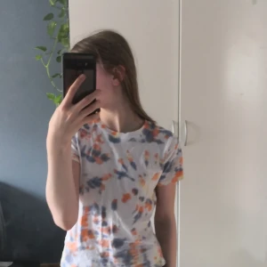 Tie dye t-shirt  - Fin tie dye t-shirt med färgerna orange, gul och blå/lila. T-shirten har 3 små hål där bak. Annars bra skick. Skriv för flera bilder🤍