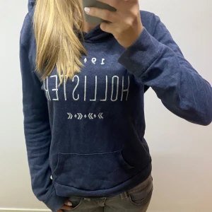 Mörkblå hoodie från hollister - Säljer en mörkblå hoodie från hollister i storlek m men skulle säga att passformen är som s!! Den är i mycket bra skick men saknar snören vid luvan!! Tröjan skulle jag säga är en lite tunnare huvtröja💗