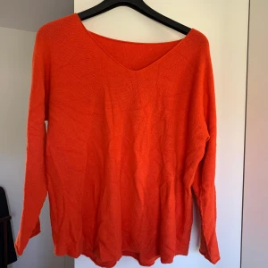 Orange Stickad Tröja - En snygg och bekväm stickadtröja i en härlig orange färg. Tröjan är tunn och har en V-ringning. Vet inte vart den är ifrån och finns ingen lapp, därav lägre pris. Den kanske är S i storlek men skulle säga att alla mellan XS-M kan ha den. 