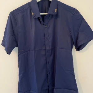 Mörkblå skjorta - Oanvänd kortärmad skjorta  Inga skador eller fläckar väldigt fräsch och ny.  Passar både S och M