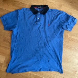 Ralph Lauren Piké - En blå Polo Ralph Lauren pikétröja med röd logga på bröstet | Gjord av 100% bomull | Storlek Large | Mycket fint skick 👍  Kolla in min profil för fler pikétröjor, skjortor och annat till bra pris! Fler varor kommer inom kort 💸
