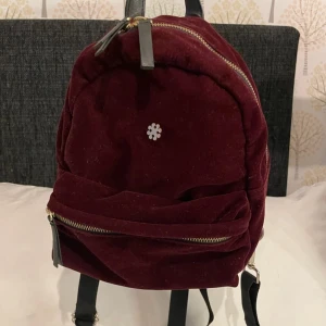 Liten ryggsäck - Liten ryggsäck i sammet. Ett stort fack och ett mindre på utsidan. I bra använt skick. 📣kolla gärna in mina andra annonser🌺