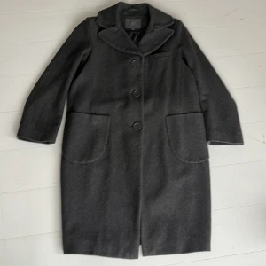 Kappa - Snygg och användbar kappa i ullblandning (60% ull, 26% polyester, 6% akryl, 4% polyamid, 4% viskos). 